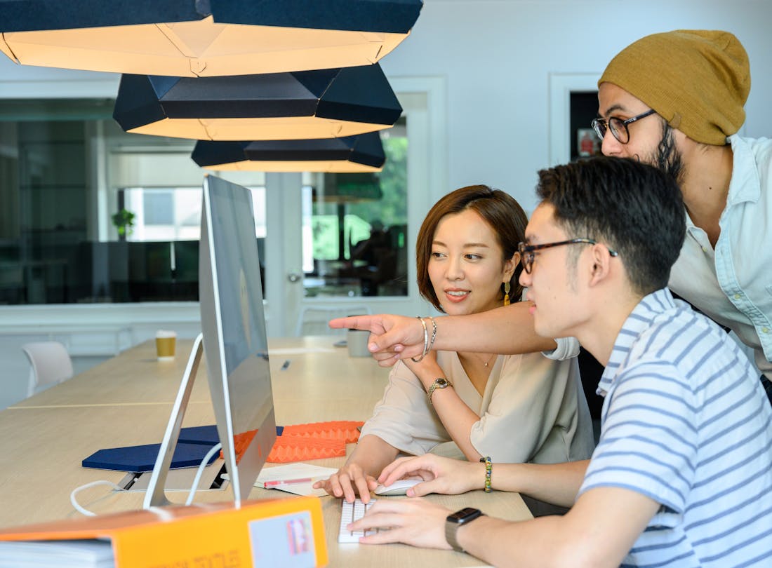 Diverse team collaborating around a computer monitor